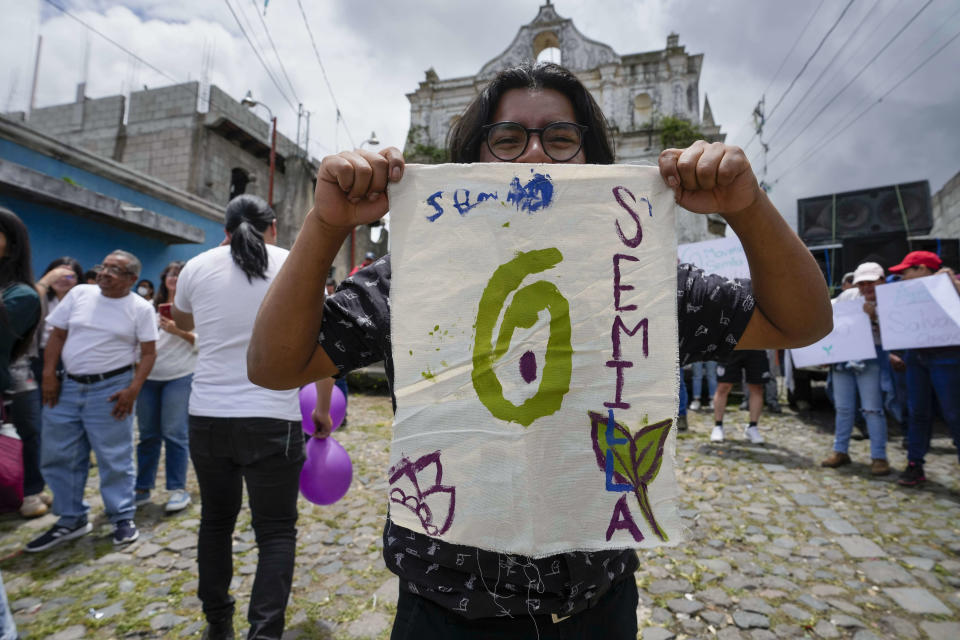 FILE - A supporter holds up a handmade Seed Movement party banner during a campaign rally for the party's presidential candidate Bernardo Arevalo, in Santa Maria de Jesus, Guatemala, July 16, 2023. Arevalo stood before residents of the Indigenous community on the slopes of the Agua Volcano and told them they could be the seeds of a brighter, more corruption-free spring in Guatemala. (AP Photo/Moises Castillo, File)