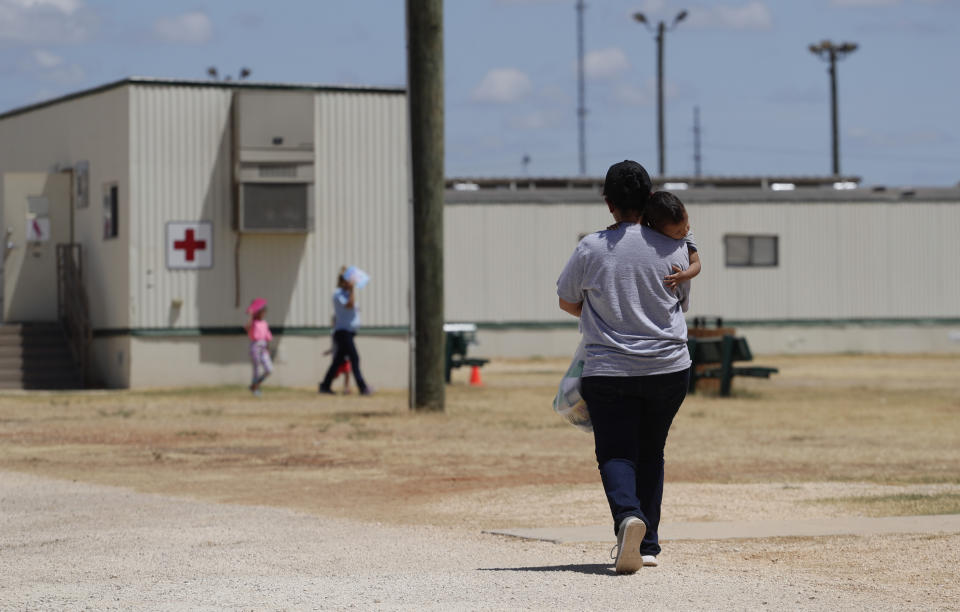 FILE - In this Aug. 23, 2019 file photo, immigrants seeking asylum walk at the ICE South Texas Family Residential Center, in Dilley, Texas. The U.S. government plans to use the downtown Dallas convention center to hold up to 3,000 immigrant teenagers as sharply higher numbers of border crossings have severely strained the current capacity to hold youths, according to a memo obtained by The Associated Press. The Kay Bailey Hutchison Convention Center will be used for up to 90 days beginning as early as this week, according to the written notification sent to members of the Dallas City Council on Monday, March 15, 2021. (AP Photo/Eric Gay, File)