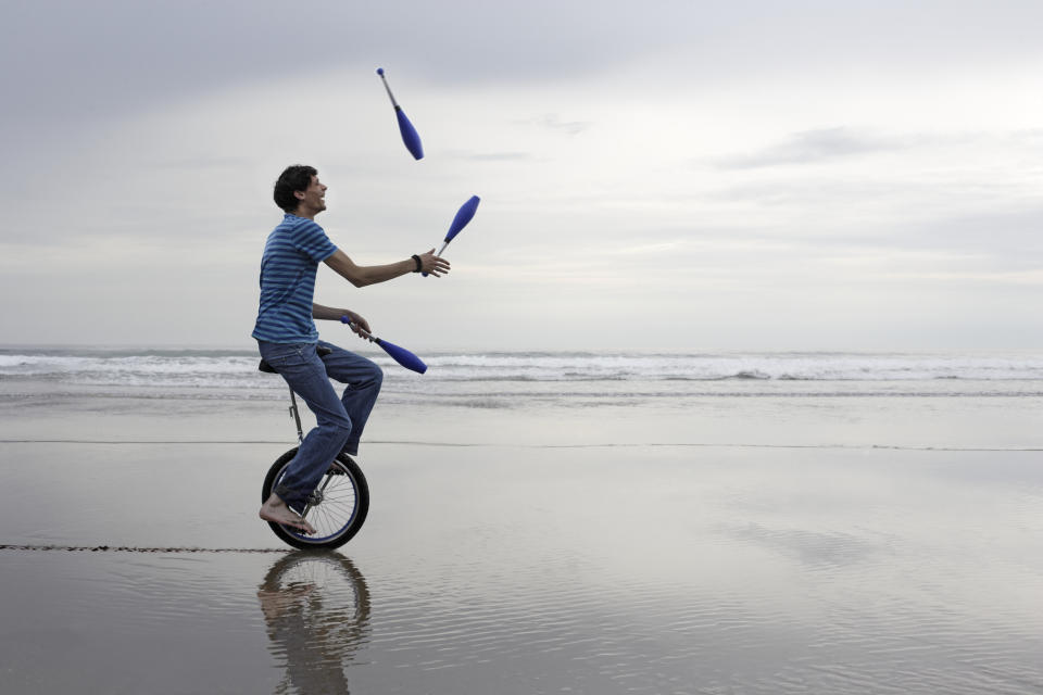 Man riding unicycle while juggling
