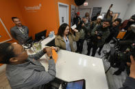 Jackie Ryan of Forest Park, Ill., becomes the first person in Illinois to purchase recreational marijuana as she purchases marijuana products from employee Brea Mooney left, at Sunnyside dispensary Wednesday, Jan. 1, 2020, in Chicago. (AP Photo/Paul Beaty)