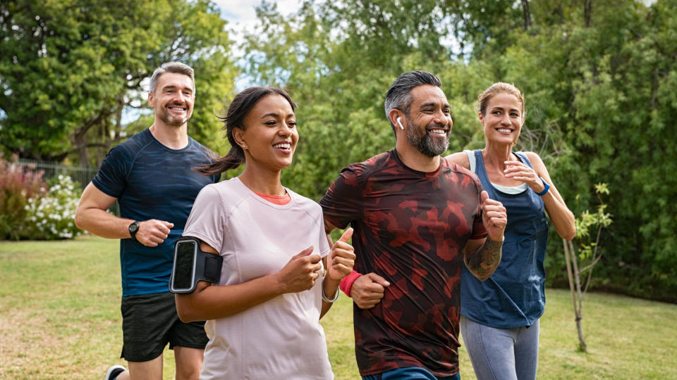 a photo of men and women running in the park together