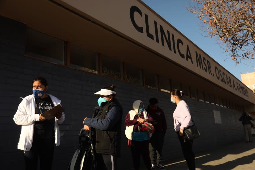 LOS ANGELES, CA - FEBRUARY 6, 2021 - A staff member of Clinica Romero, left, registers patients at a COVID-19 vaccination clinic for patients 75 years of age or older in Los Angeles on Saturday morning, February 6, 2021. Clinca Romero has 12,000 patients who are mostly Central American essential workers and has only received 100 vaccines. Only 43 vaccines were given at the first clinic. Clinica Romero had expected a lot more vaccines for a community that is one of the hardest hit areas with COVID-19 in Los Angeles. According to the clinic's providers, since the start of the pandemic in March 2020, Clinica patients have demonstrated a consistent COVID positivity rate at 40%. "The number of members of our community and staff who have been infected with COVID-19 is concerning and disheartening," said Carlos Vaquerano, executive director at Clinica Romero. (Genaro Molina / Los Angeles Times)