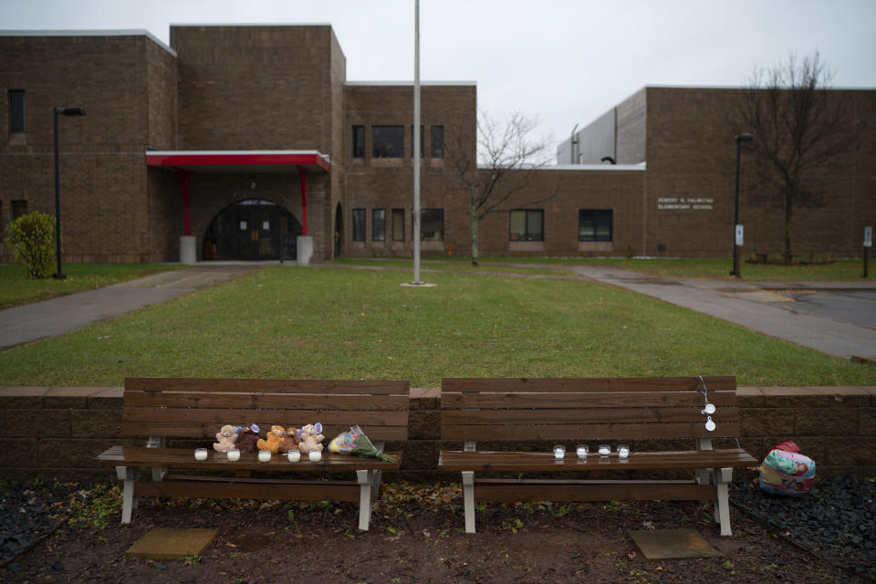 Teddy bears, flowers, and candles were placed on benches outside Halmstad Elementary School in Chippewa Falls, Wis. as a memorial to the three Girl Scouts who were struck and killed by a driver who fled the scene, Sunday, Nov. 4, 2018. The western Wisconsin community is grieving the deaths of three girls and an adult who were collecting trash along a rural highway when police say a pickup truck veered off the road and hit them before speeding away. (Jeff Wheeler/Star Tribune via AP)