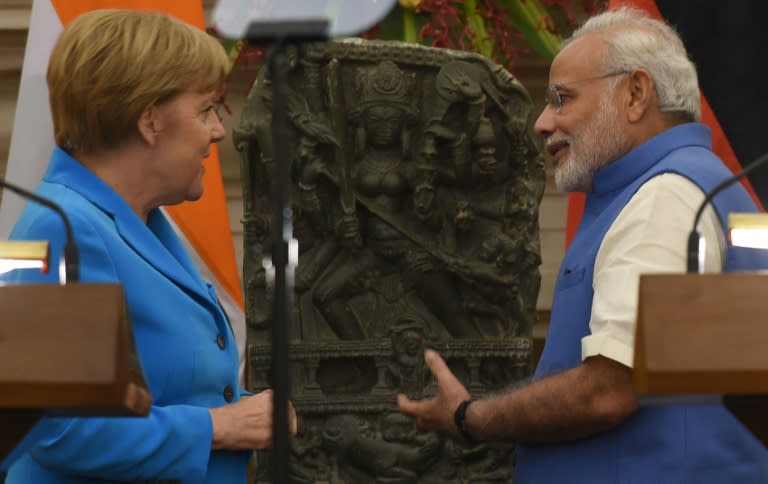 German Chancellor Angela Merkel (left) speaks with India's Prime Minister Narendra Modi as they prepare to address a press conference in New Delhi on October 5, 2015
