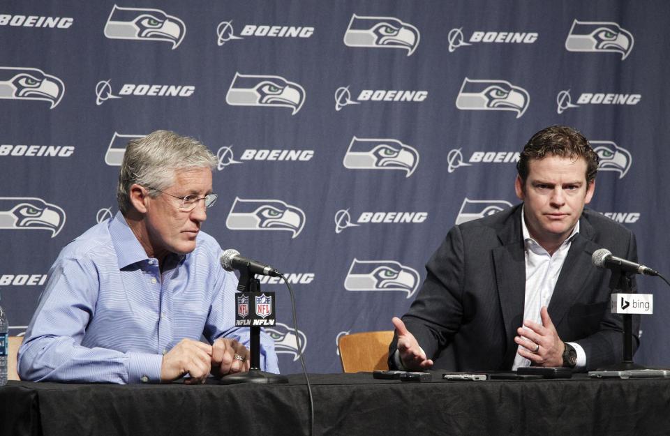 Seattle Seahawks NFL football head coach Pete Carroll, left, and Seattle Seahawks general manager John Schneider, right, talk to the media during a news conference Friday, April 4, 2014, in Renton, Wash. The Seahawks have locked up coach Carroll with a three-year contract extension after he led the franchise to its first Super Bowl title. (AP Photo/Marcus R. Donner)