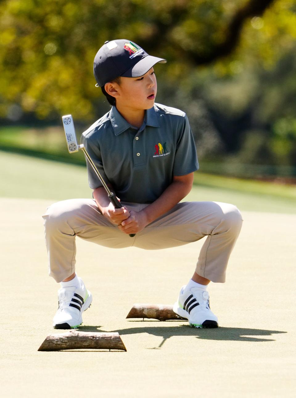 Ethan Jung from Fort Lee, N.J., watches one of his putts during the Drive, Chip & Putt National Finals competition at Augusta National Golf Club.