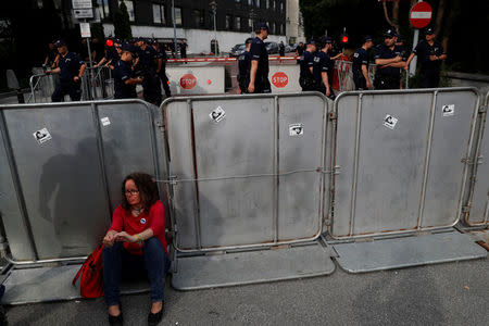 Woman seats near police barrier as she takes part in an anti-government protest in support of free courts outside the Parliament building in Warsaw, Poland July 18, 2018. REUTERS/Kacper Pempel