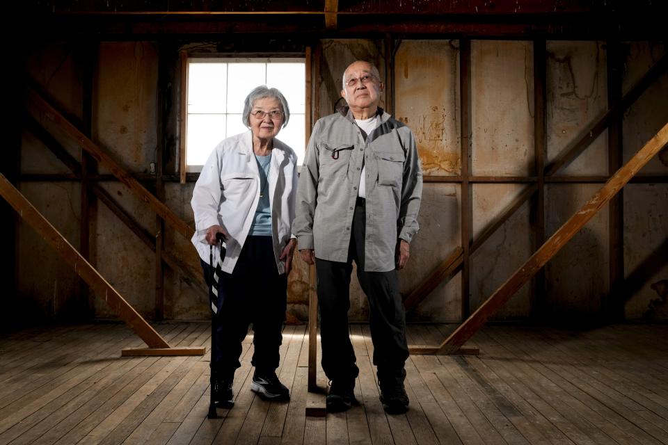 Minidoka survivor Paul Tomita, right, poses for a photograph with his wife Mabel Imai Tomita, a Gila River and Tule Lake survivor, in an original barracks at Minidoka National Historic Site, Saturday, July 8, 2023, in Jerome, Idaho. Paul, who had asthma as an infant, remembers the desert dust repeatedly sending him to the camp hospital. Now in their 80s, the Tomitas have traveled to participate in many pilgrimages to Japanese-American incarceration sites. "We have to make sure that it doesn't happen again. And the only way we do is we have to participate," said Paul Tomita. (AP Photo/Lindsey Wasson)