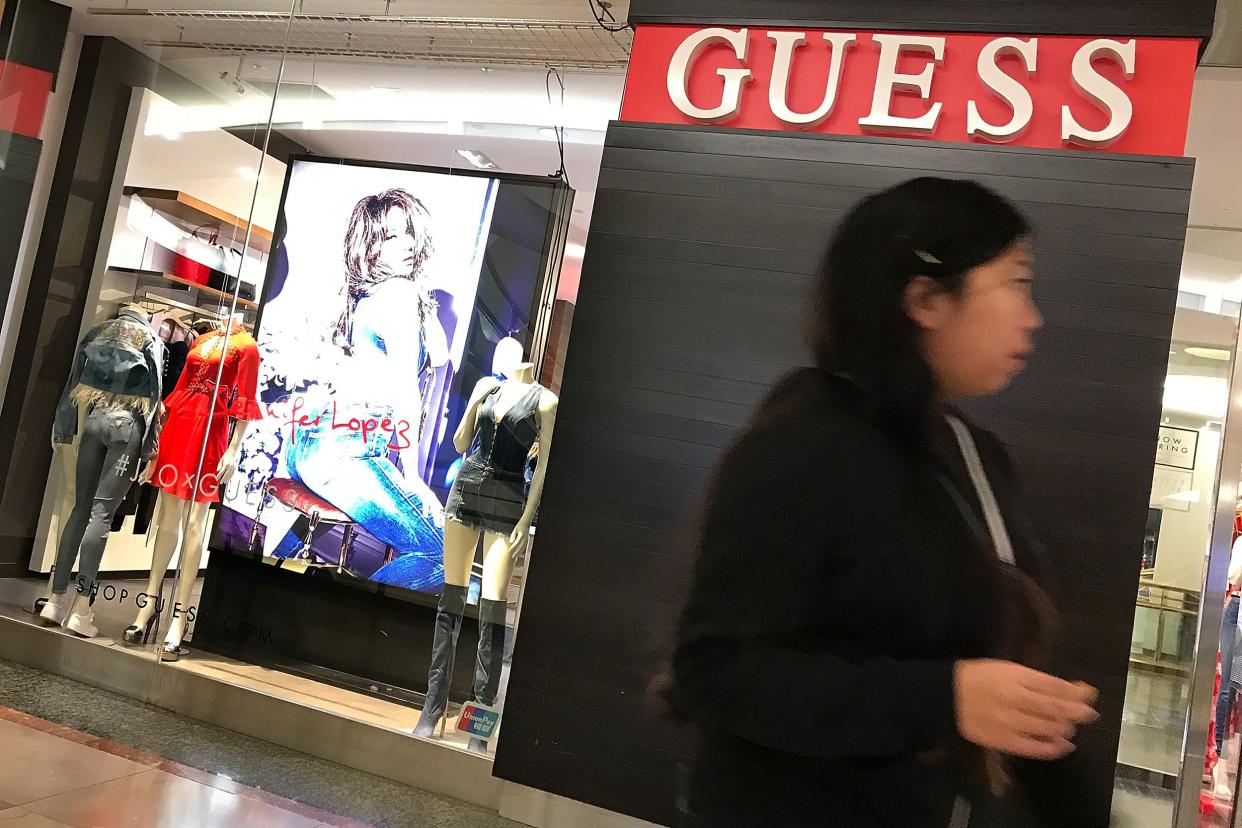 A shopper walks by a Guess store on February 1, 2018 in San Francisco, California.