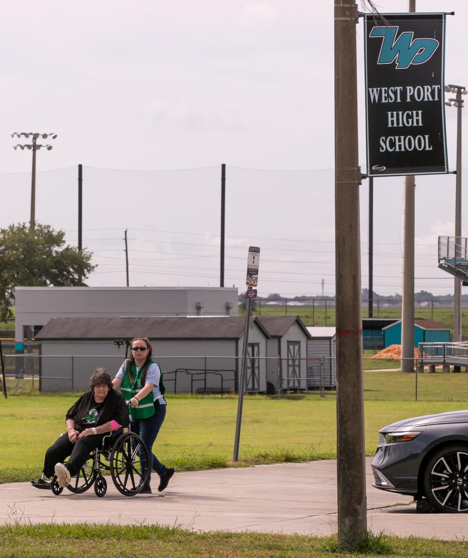 Cathy Hipsley is wheeled into the special-needs shelter at West Port High School on Tuesday.