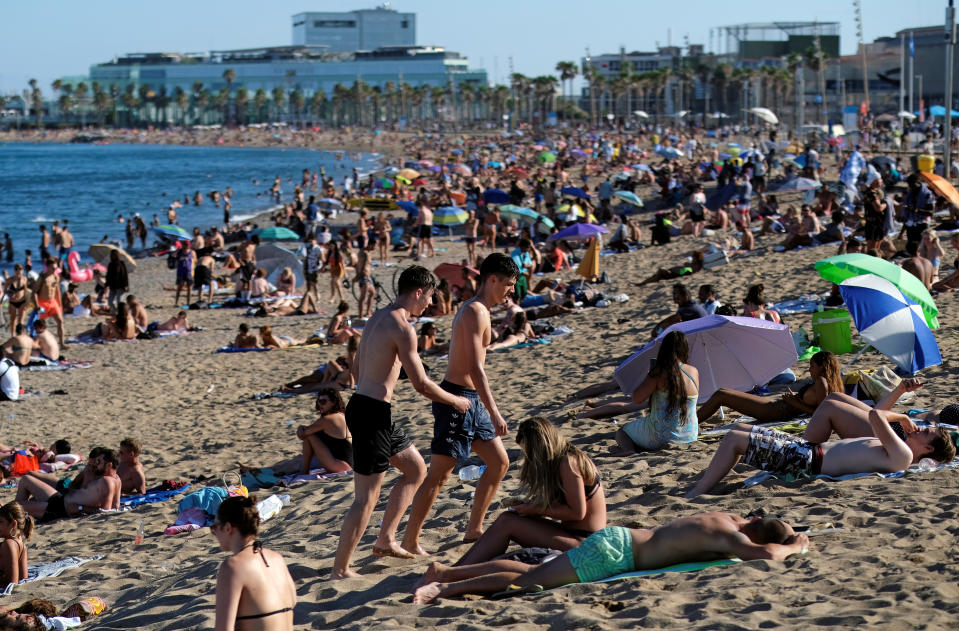 People enjoy the sunny weather at Barceloneta beach, after Catalonia's regional authorities and the city council announced restrictions to contain the spread of the coronavirus disease (COVID-19) in Barcelona, Spain July 19, 2020. REUTERS/Nacho Doce