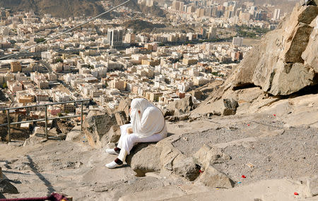 A muslim pilgrim prays while she climbs the Mount Al-Noor, where Muslims believe Prophet Mohammad received the first words of the Koran through Gabriel in the Hera cave, ahead of annual Haj pilgrimage in the holy city of Mecca, Saudi Arabia August 18, 2018. REUTERS/Zohra Bensemra