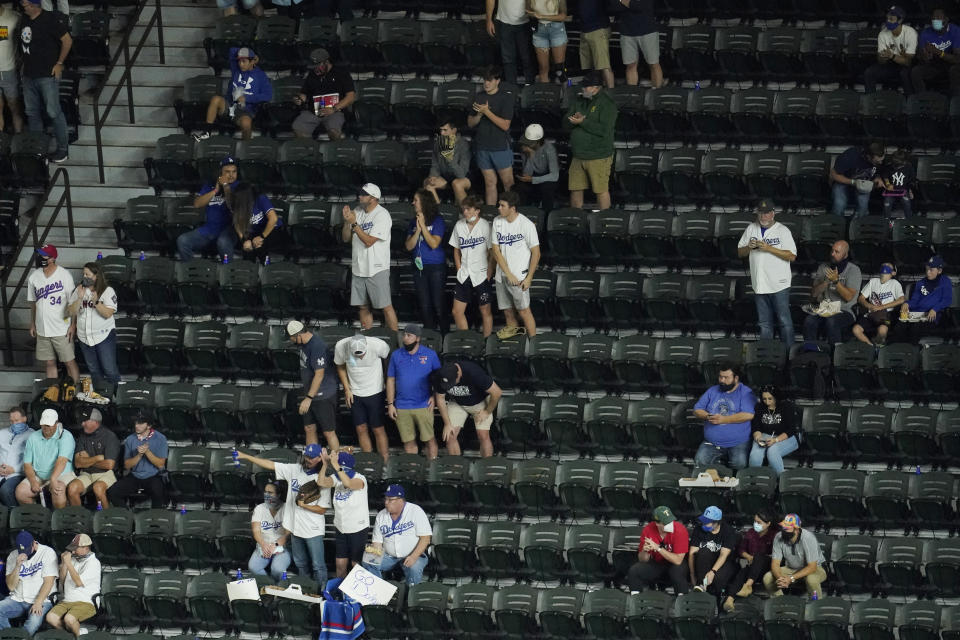 Fans watch during the fourth inning in Game 2 of the baseball World Series between the Los Angeles Dodgers and the Tampa Bay Rays Wednesday, Oct. 21, 2020, in Arlington, Texas. (AP Photo/David J. Phillip)