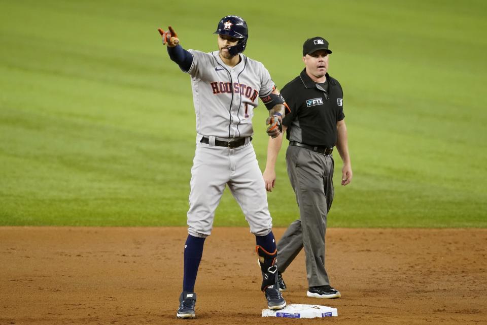 Houston Astros shortstop Carlos Correa (1) celebrates his two-run double as umpire Nick Mahrley looks on in the first inning of a baseball game against the Texas Rangers in Arlington, Texas, Monday, Sept. 13, 2021. The hit scored Yordan Alvarez and Yuli Gurriel. (AP Photo/Tony Gutierrez)