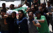 Mourners chant Islamic slogans while carrying the body of Awad Abu Selmiya, during a funeral of thirteen Hamas militants outside a mosque in Gaza City, Thursday, May 13, 2021. Gaza residents are bracing for more devastation as militants fire one barrage of rockets after another and Israel carries out waves of airstrikes. (AP Photo/Adel Hana)