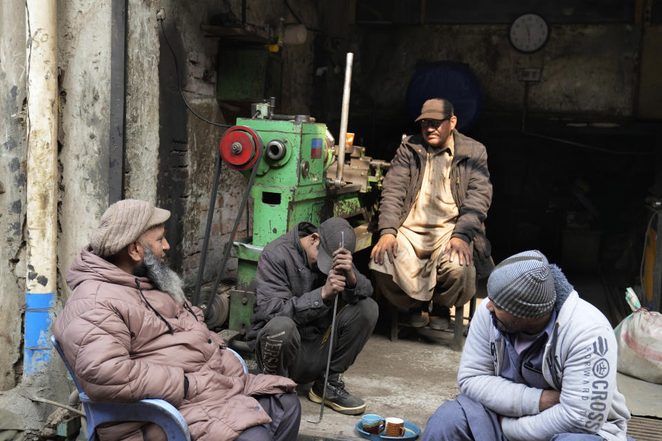 Workers wait for electricity outside their workshop following a power breakdown across the country, in Lahore, Pakistan, Monday, Jan. 23, 2023. Much of Pakistan was left without power for several hours on Monday morning as an energy-saving measure by the government backfired. The outage spread panic and raised questions about the cash-strapped government’s handling of the crisis. (AP Photo/K.M. Chaudary)