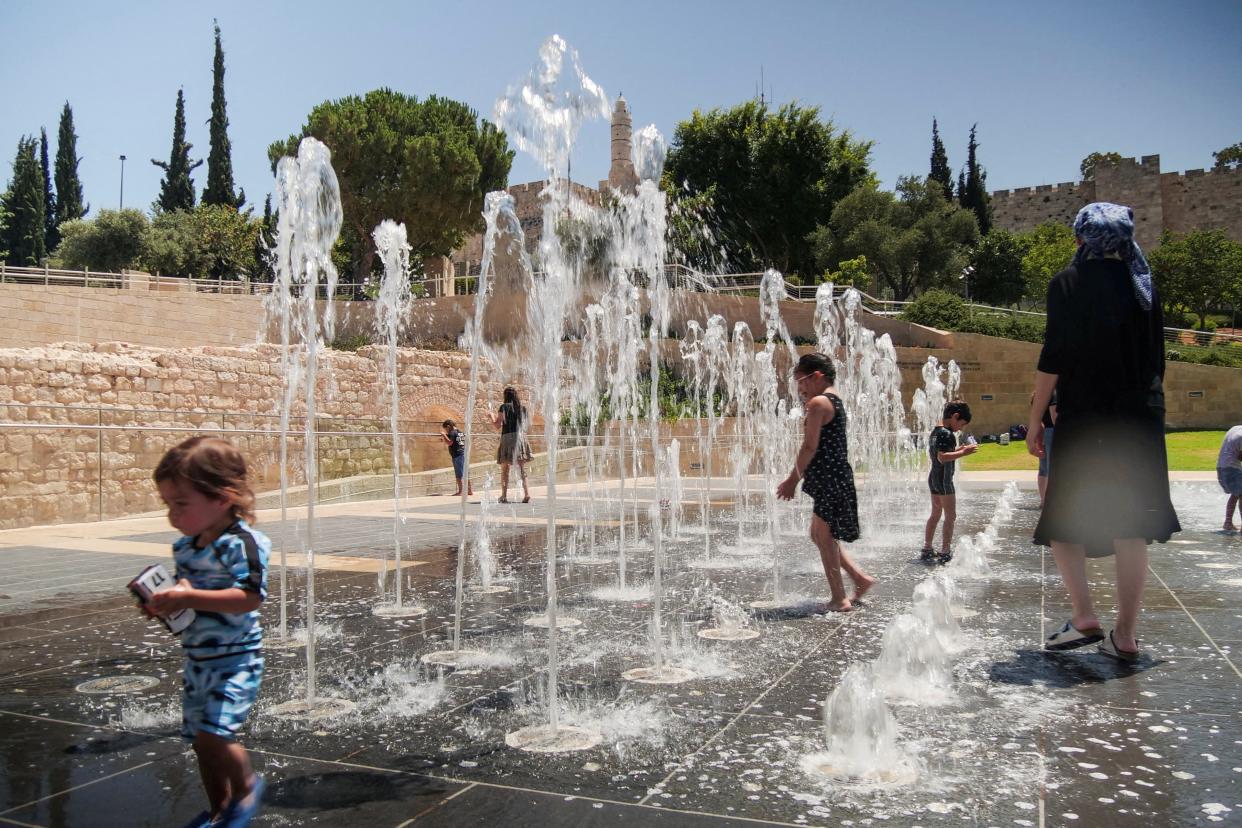 Children play in a water fountain near the walls of Jerusalem's Old City (REUTERS)