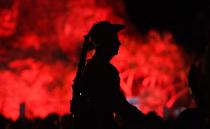 A horseman stands mounted before a red-lit Elephant Rock at Currubin RSL on the Gold Coast. Source: AAP