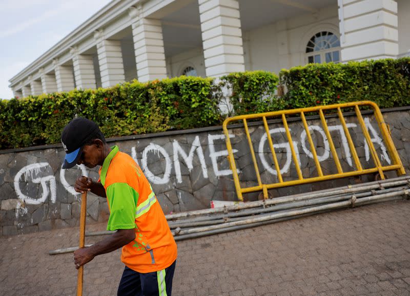 A man sweeps the road to President's official residence, in Colombo