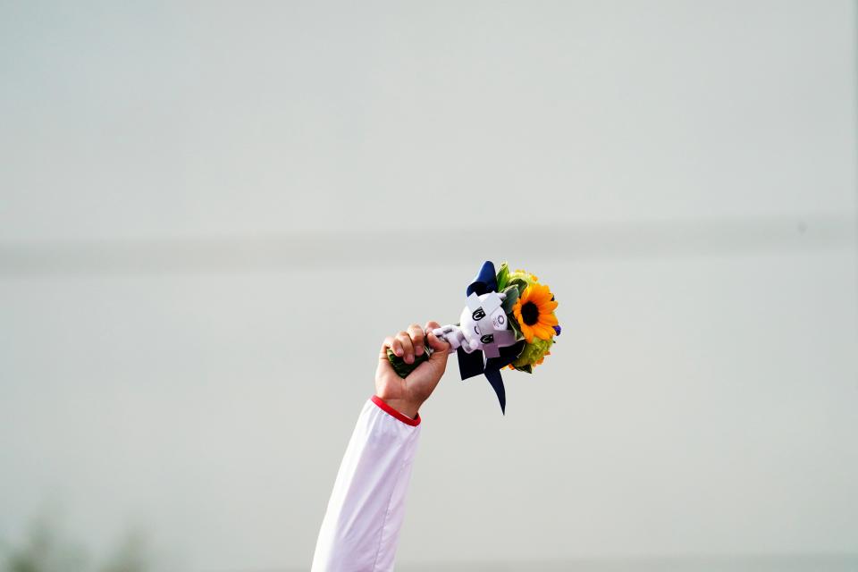 David Kostelecky (CZE) holds up flowers and Miraitowa, the Tokyo Olympic mascot, while standing on the medal podium during the Tokyo 2020 Olympic Summer Games at Asaka Shooting Range on July 29, 2021.