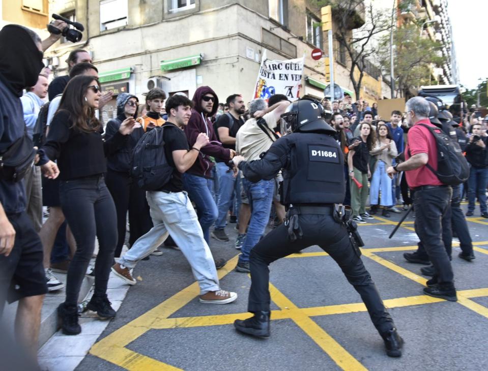 Police and demonstrators clash outside the Louis Vuitton show in Barcelona (AP)