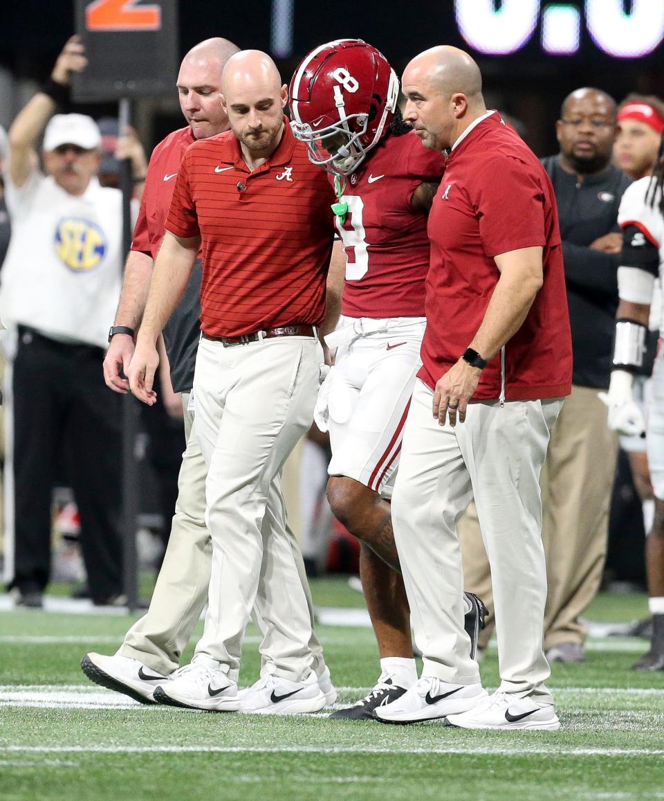 Dec 4, 2021; Atlanta, GA, USA; Trainers help Alabama wide receiver John Metchie III (8) off the field after he suffeed an injury while playing against Georgia during the SEC championship game at Mercedes-Benz Stadium. Mandatory Credit: Gary Cosby Jr.-USA TODAY Sports