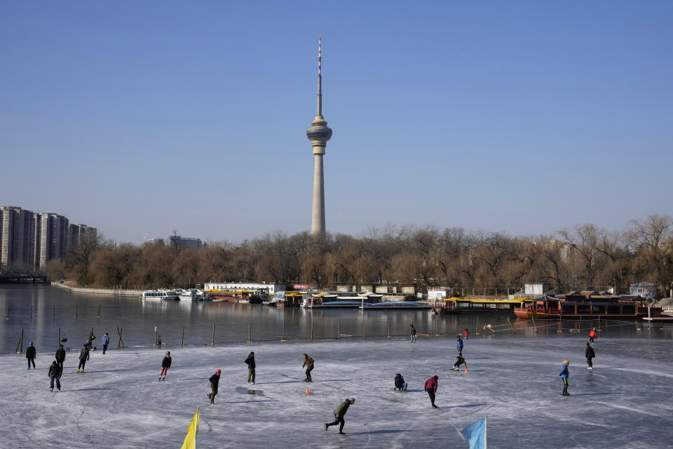 Residents skate on a frozen lake in Beijing, China, Tuesday, Jan. 11, 2022. The Chinese capital is on high alert ahead of the Winter Olympics as China locks down a third city elsewhere for COVID-19 outbreak. (AP Photo/Ng Han Guan)