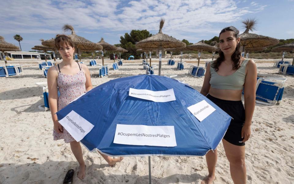 Lucia Luna, left, and Marina Vaquer join the protest on the beach at Sa Rapita