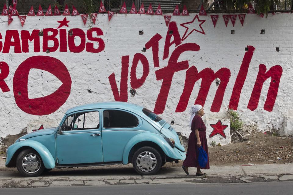 Una mujer camina frente a un muro pintado con un mensaje de promoción electoral del partido en el gobierno, el FMLN, en San Salvador el sábado 8 de marzo de 2014. (Foto AP/Esteban Félix)