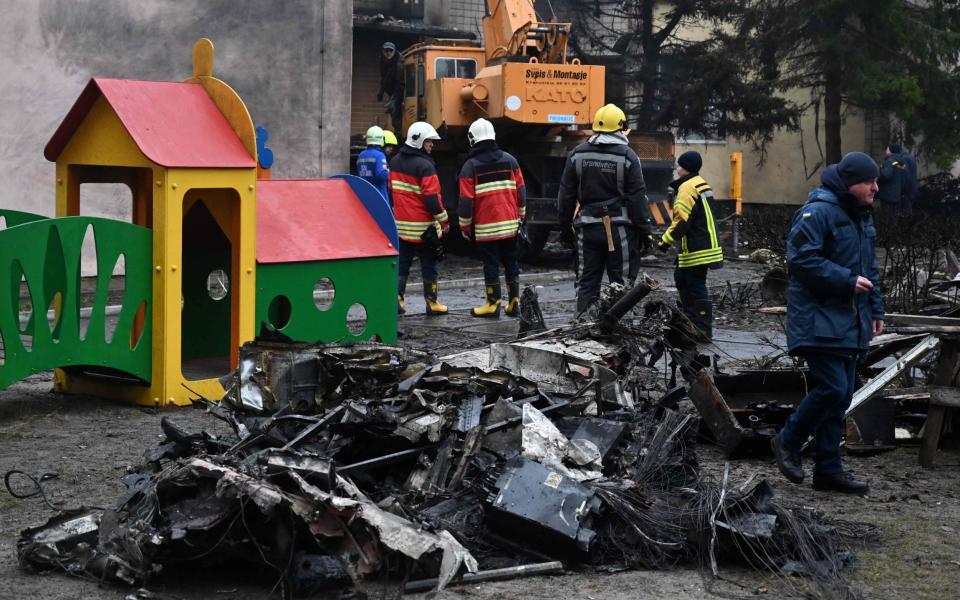 Firefighters work near the site where a helicopter crashed near a kindergarten in Brovary - SERGEI SUPINSKY/AFP