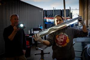 Pacific Northwest National Laboratory researchers Robert Mueller and Kate Deters inspect an American eel in a water-filled tube following its safe passage through Natel Energy's Restoration Hydro Turbine. Alameda, CA, 2021.