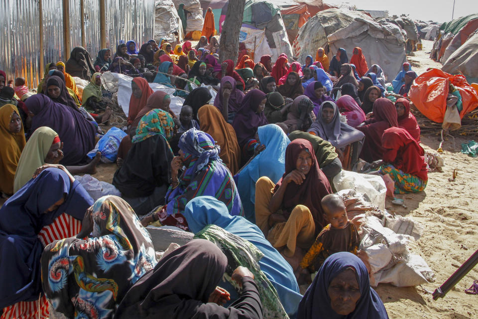 Somalis who fled drought-stricken areas sit at a makeshift camp on the outskirts of the capital Mogadishu, Somalia Friday, Feb. 4, 2022. Thousands of desperate families have fled a severe drought across large parts of Somalia, seeking food and water in camps for displaced people outside the capital. (AP Photo/Farah Abdi Warsameh)