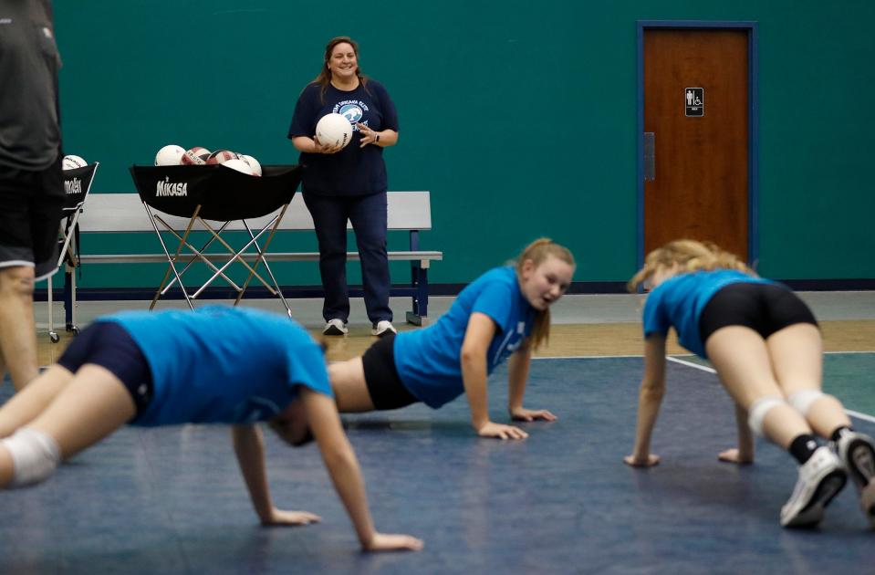 Team Indiana Thundercats head volleyball coach Rebecca Murray watches her team do pushups during practice Monday, Feb. 28, 2022, in Indianapolis. Murray is in her 19th season coaching 11- and 12-year-old girls for Team Indiana. 