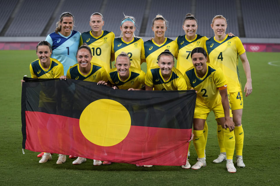 FILE - Australia players pose for a group photo with the Aboriginal flag prior to women's soccer match against New Zealand at the 2020 Summer Olympics, July 21, 2021, in Tokyo. FIFA President Gianni Infantino confirmed the decision on Friday, July 7, 2023, that First Nations flags will be flown at Women's World Cup stadiums in Australia and New Zealand after soccer's world governing body agreed to make exceptions to the usually tight FIFA match day regulations for tournament venues. (AP Photo/Ricardo Mazalan, File)