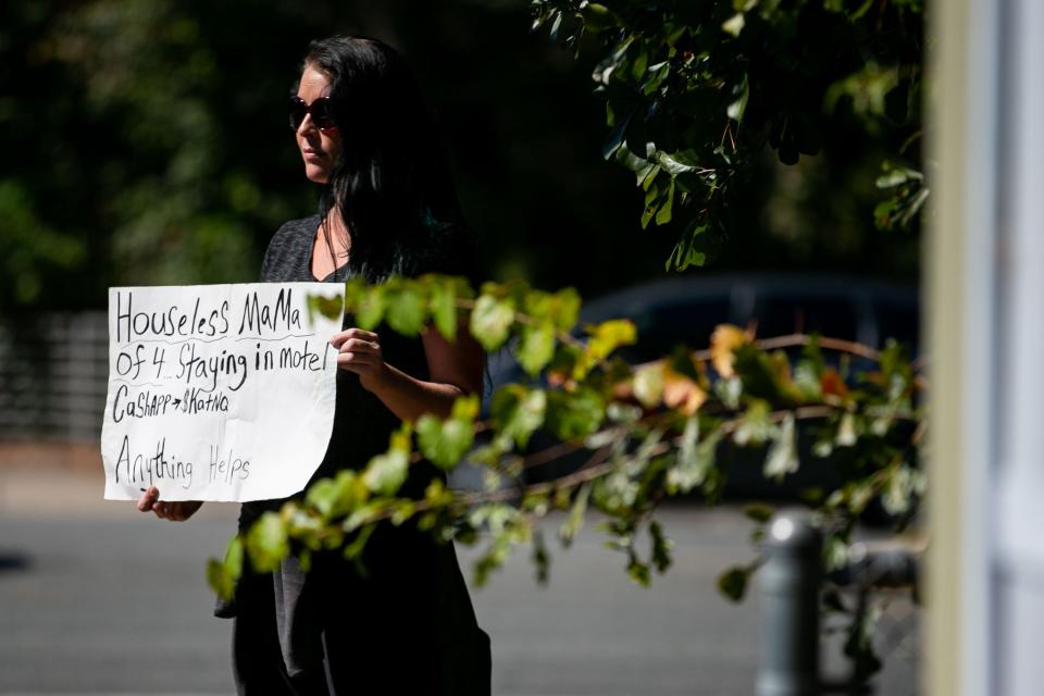 Danica Hively stands at the corner of  Governors Crossing shopping plaza panhandling for money to feed her family with a sign that reads "Houseless mama of 4 staying in motel. CashApp $KatNQ Anything helps," Friday, Oct. 21, 2022.