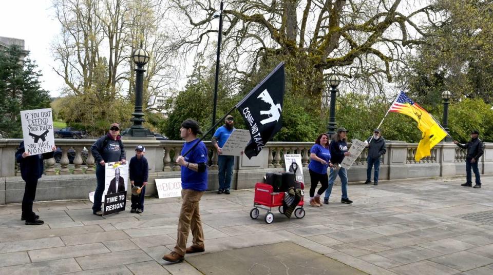 With recorded patriotic music loudly playing in the background a small but vocal group of gun rights supporters gather to chant and shout their protests just below the office of Gov. Jay Inslee around the time of his signing of a firearms bill package on April 25,2023. Washington state became the 10th state in the U.S. to ban assault weapons on Tuesday when Gov. Jay Inslee signed the bill passed by this year’s legislature as part of a sweeping package of proposals aimed at reducing gun violence.