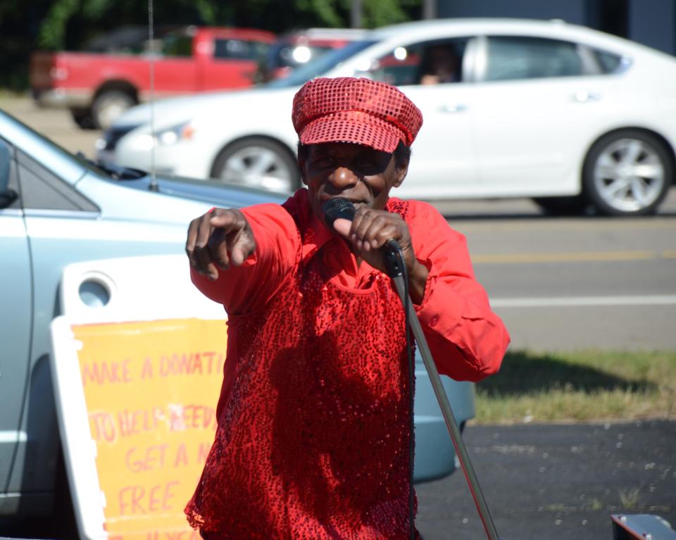 Bobby Holley performs in the Pennfield Plaza as he collects donations for his bicycle give-away campaign.