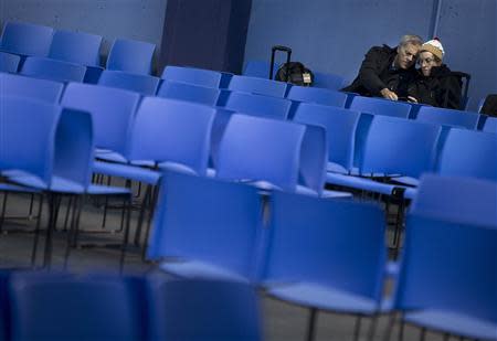 People sit in a departure lounge after Royal Caribbean's cruise ship, Explorer of the Seas arrived back at Bayonne, New Jersey January 29, 2014. REUTERS/Carlo Allegri