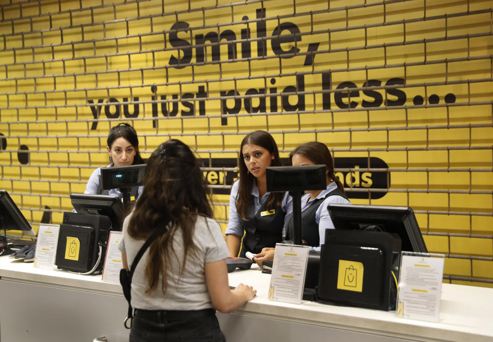 A customer asks employees if she can still enter an international fashion and homeware retailer that will temporarily shut down from Friday in the face of an increasingly volatile currency market and their inability to set prices while the Lebanese pound plunges against the dollar, in Beirut, Lebanon, Thursday July 2, 2020. Later in the day, owners of the businesses rallied in central Beirut to denounce the government's inability to handle a deepening economic and financial crisis, and urging others to join them after the Lebanese pound recorded a new low Thursday, selling at nearly 10,000 for a dollar and maintaining the downward slide that saw the national currency lose about 85% of its value over the past months. (AP Photo/Hussein Malla)