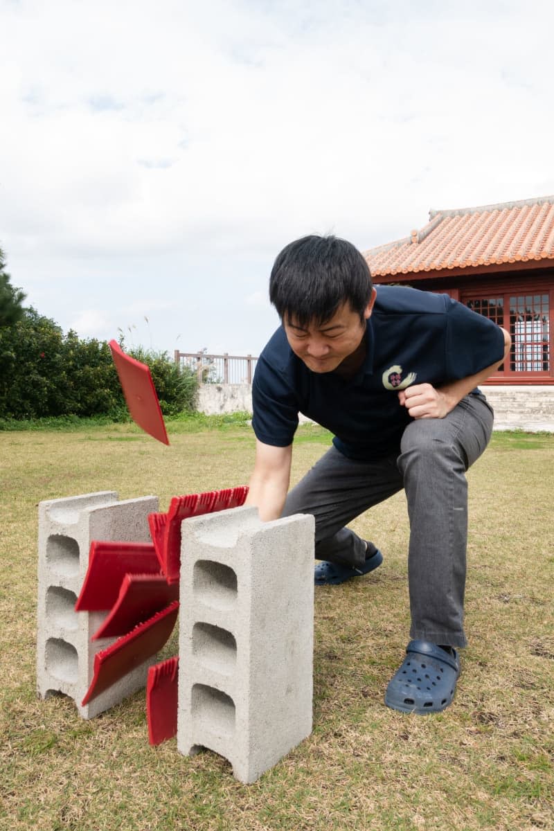 Terumitsu Taira breaks through roof tiles made out of hard plastic. Andreas Drouve/dpa
