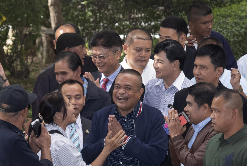 Jatuporn Phromphan, front center, one of the leaders of Red Shirt, talks to his supporters on his arrival at the Bangkok Criminal Court in Bangkok, Thailand, Wednesday, Aug. 14, 2019. The court has dismissed charges of terrorism and other offenses against 24 leaders of an extended street protest in 2010 that saw key parts of central Bangkok closed off and random violence that was ended by armed military force. (AP Photo/Sakchai Lalit)