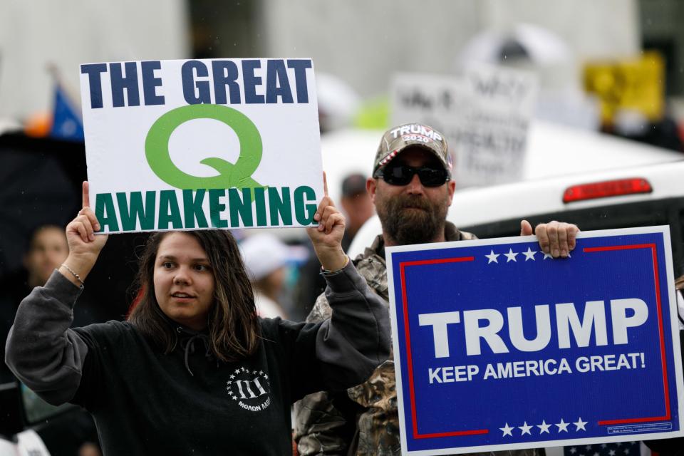 Demonstrators hold signs promoting the QAnon conspiracy theory and President Donald Trump while protesting coronavirus restrictions at the State Capitol in Salem, Ore. on May 2, 2020. (John Rudoff/Anadolu Agency via Getty Images)