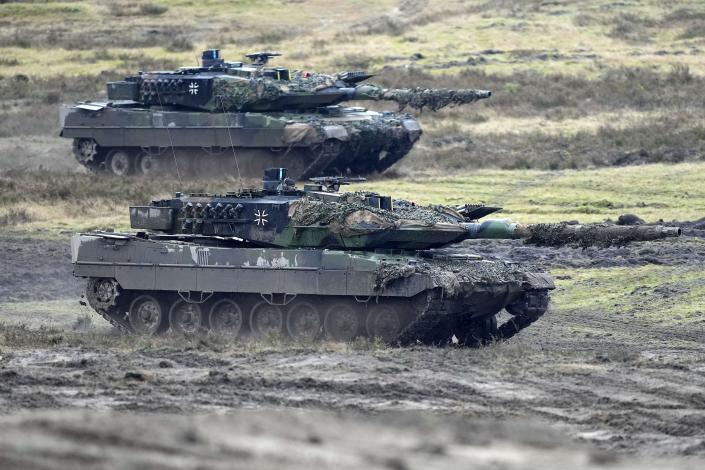 FILE - Two Leopard 2 tanks are seen in action at the Field Marshal Rommel Barracks in Augustdorf, Germany, Wednesday, Feb. 1, 2023. Germany wants to buy back mothballed Leopard 2 tanks from Switzerland to replace tanks that Berlin and its Western allies are sending to Ukraine, the Swiss government said Friday. (AP Photo/Martin Meissner, File)