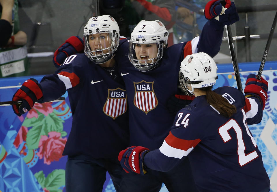 Meghan Duggan, Monique Lamoureux and Josephine Pucci of the Untied States (L-R) celebrate Lamoureux's goal against Switzerland during the 2014 Winter Olympics women's ice hockey game at Shayba Arena, Monday, Feb. 10, 2014, in Sochi, Russia. USA defeated Switzerland 9-0. (AP Photo/Petr David Josek)