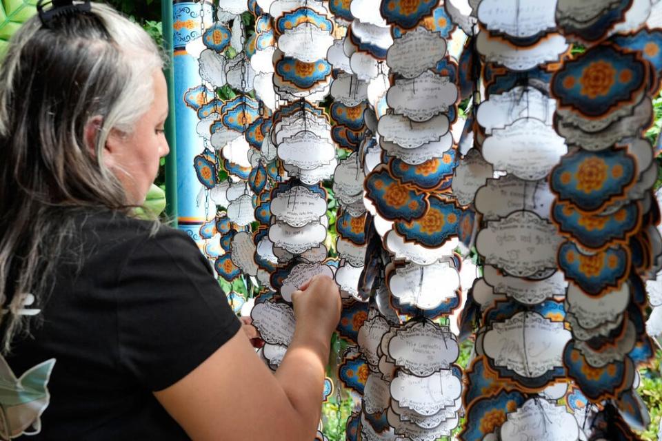 Cynthia Garcia, 41, hangs a note on the Memory Wall in Plaza de la Familia at Disney California Adventure Park. The Memory Wall is an area where guests can leave notes to honor deceased loved ones.