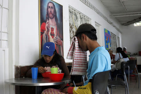 Marlon Carrillo (R) and his wife Yorgelis Materan have lunch in a church-run soup kitchen in Cucuta, Colombia December 15, 2017. REUTERS/Carlos Eduardo Ramirez