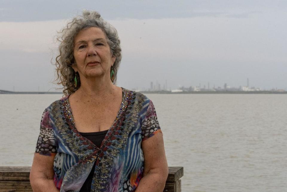 Diane Wilson stands in Port Lavaca, across Lavaca Bay from the Formosa Plastics Corp. Plant, pictured on July 23, 2023.
