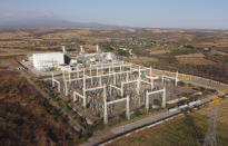 A newly built power generation plant is seen with the Popocatepetl Volcano in the background near Huexca, Morelos state, Mexico, Saturday, Feb. 22, 2020. The power plant is part of a mega-energy project that includes a natural gas pipeline that traverses three states. (AP Photo/Eduardo Verdugo)