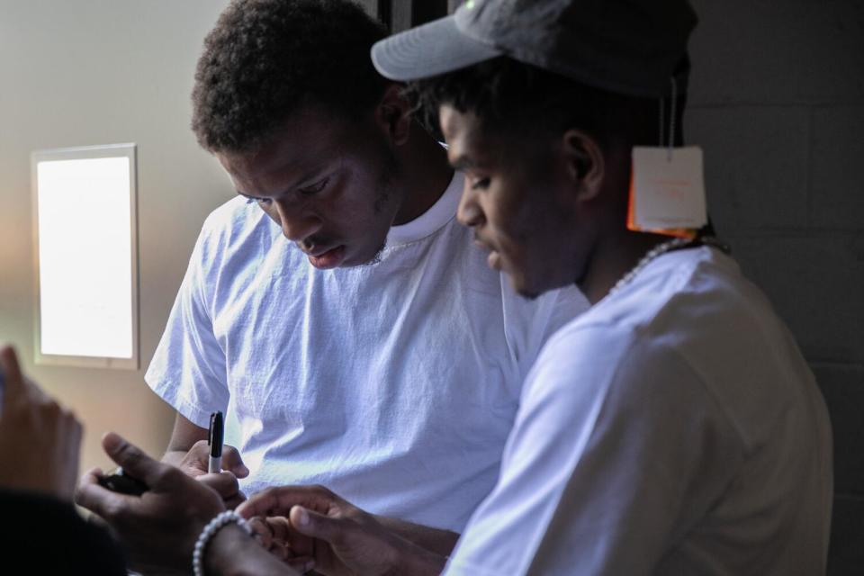 Marveon Mabon, left, leads a backpack distribution event for children at the Watts Empowerment Center.