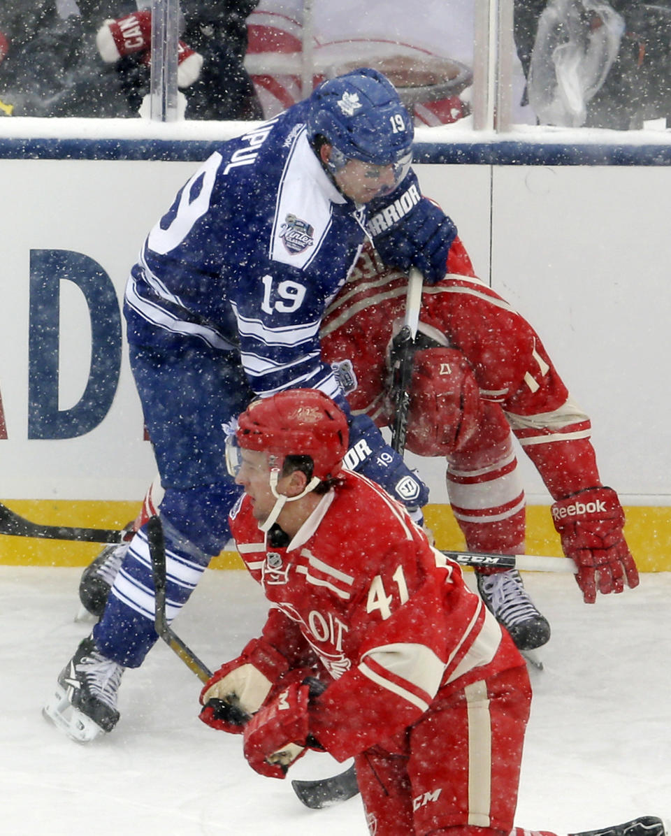 Toronto Maple Leafs right wing Joffrey Lupul (19) cross checks Detroit Red Wings forward Patrick Eaves during the first period of the Winter Classic outdoor NHL hockey game at Michigan Stadium in Ann Arbor, Mich., Wednesday, Jan. 1, 2014. Lupul received a two-minute penalty, and Eaves left the ice after hit. (AP Photo/Carlos Osorio)